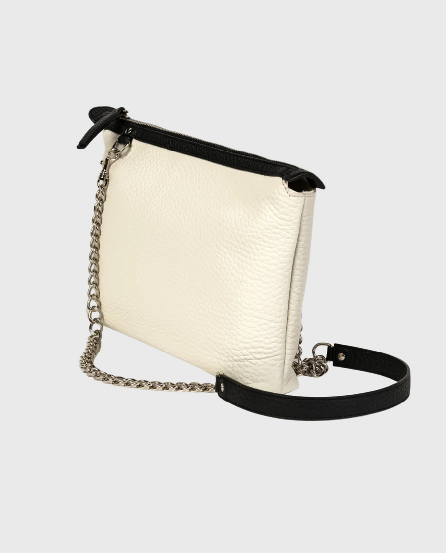 A white crossbody leather bag with black detailing, a silver-tone chain strap, and a top zip closure.